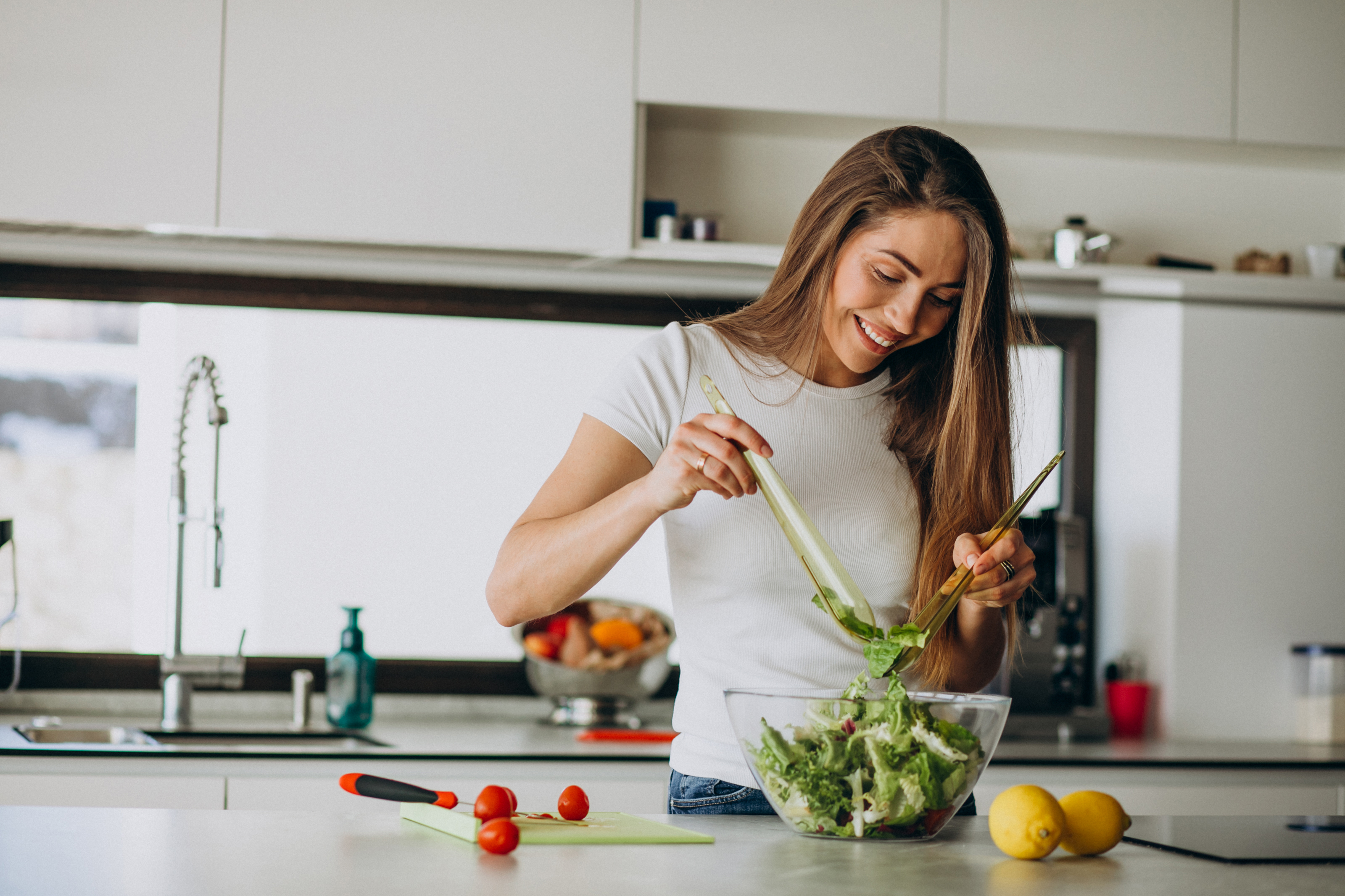 mulher jovem preparando uma salada na cozinha